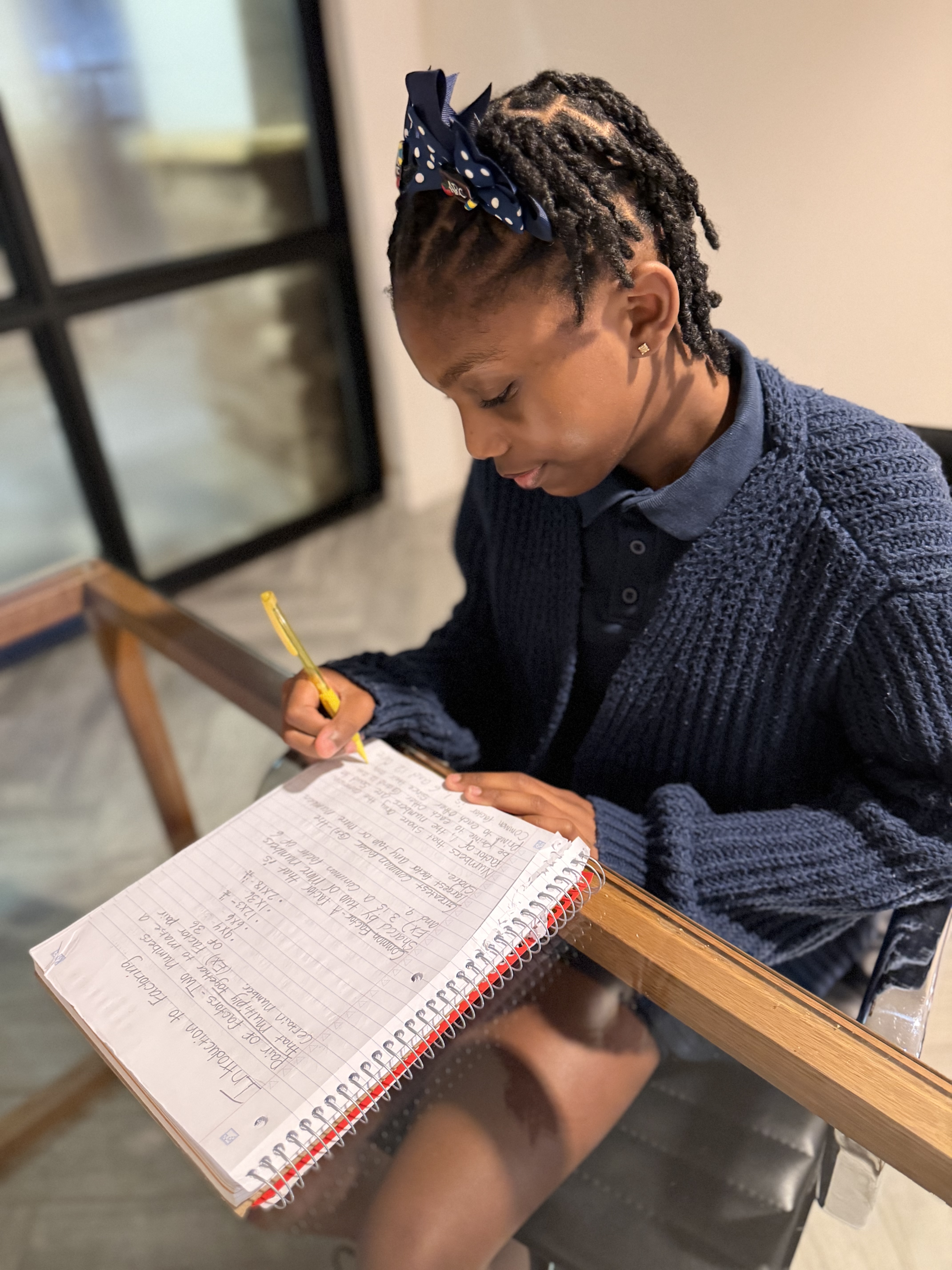 A student working through math problems in a notebook